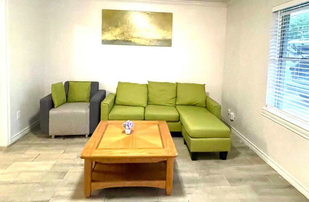 a living room with a green couch and a coffee table at Room near downtown Dallas4 in Dallas