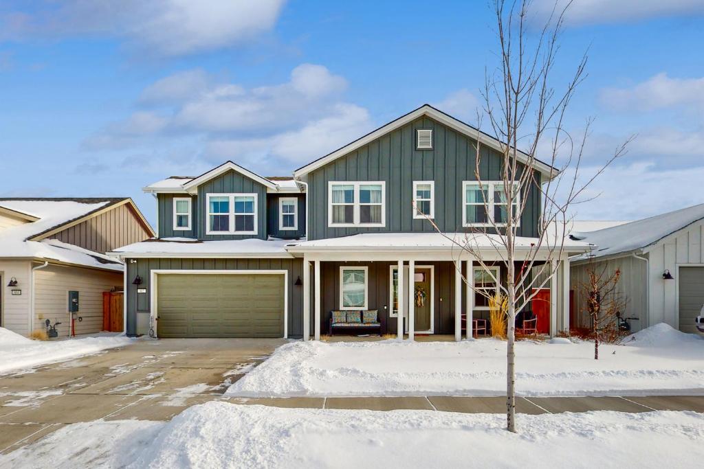 uma casa verde com garagem na neve em Blue Skies Over Butler Creek em Belgrade