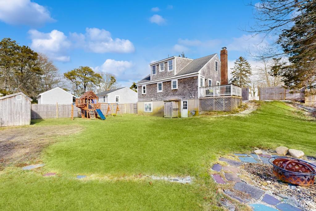 una casa con un parque infantil en el patio en Sand Dollar Dreams, en Harwich