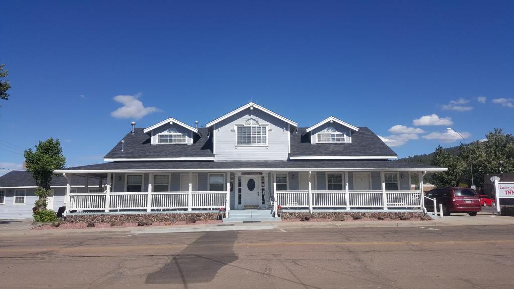 uma casa branca com um telhado preto em Canyon Country Inn em Williams