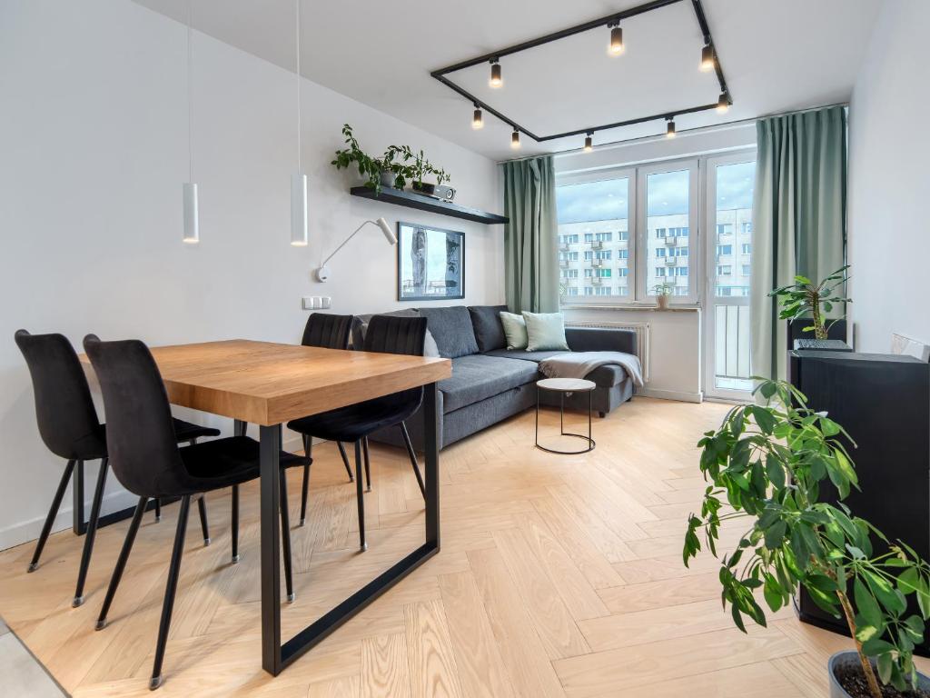 a living room with a table and a couch at Seaside Retreat Gdańsk - 64m2, Parking, Workspace- by Rentujemy in Gdańsk