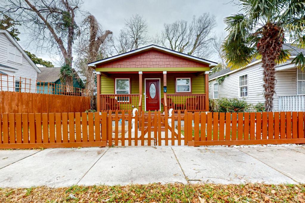 a yellow and red house with a wooden fence at Orange Street Haven in Wilmington