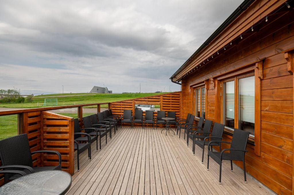 une terrasse avec des chaises et des tables dans un bâtiment dans l'établissement Gladheimar Guesthouse, à Blönduós