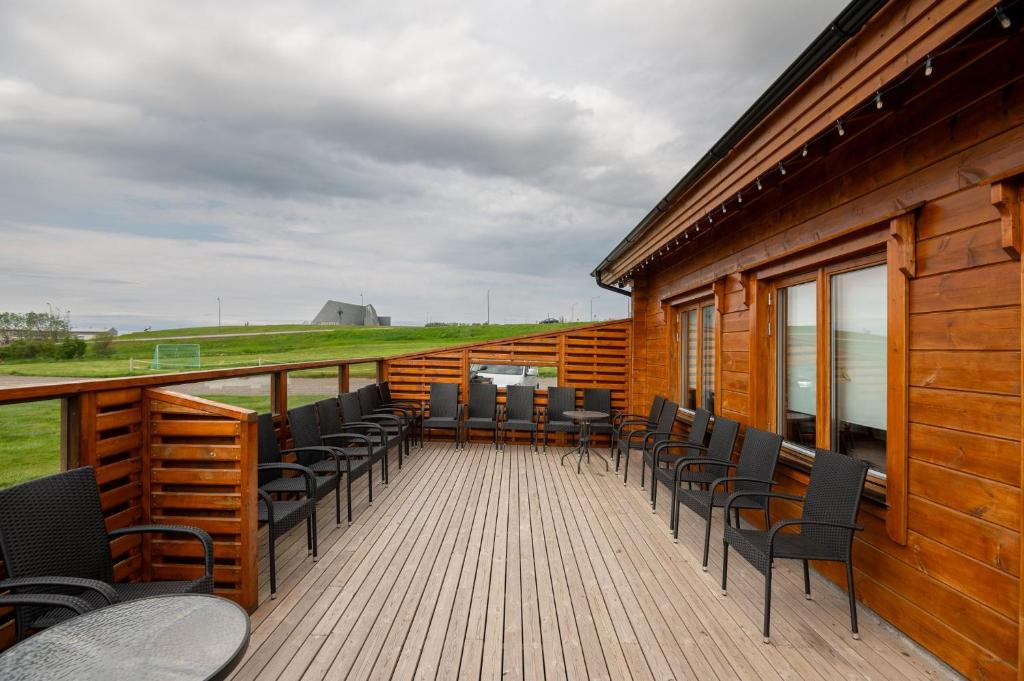 um deque com cadeiras e mesas num edifício em Gladheimar Guesthouse em Blönduós