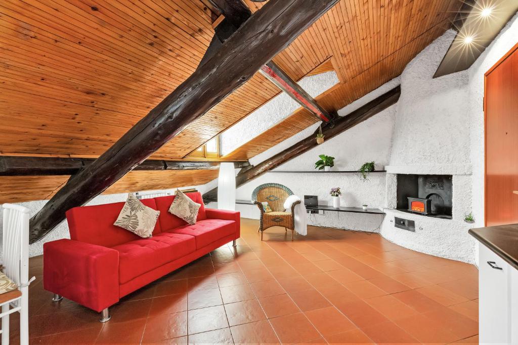 un divano rosso in un soggiorno con soffitto in legno di Porta Venezia-Buenos Aires Chalet House in Shopping District Free Wifi Netflix a Milano
