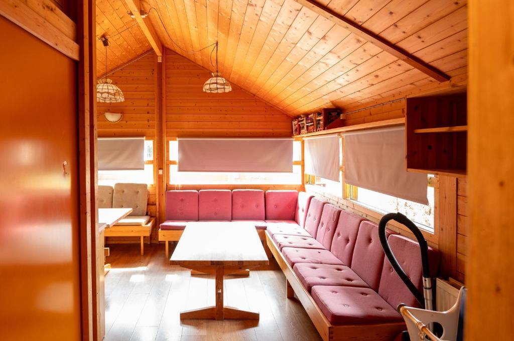 una sala de tren con asientos rojos y una mesa en Gladheimar Cottages, en Blönduós