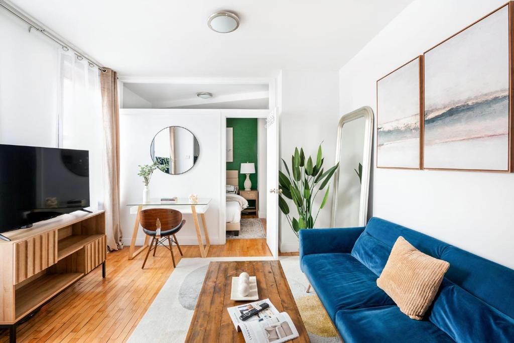 uma sala de estar com um sofá azul e uma mesa em 139-3E west village 1BR best value em Nova Iorque