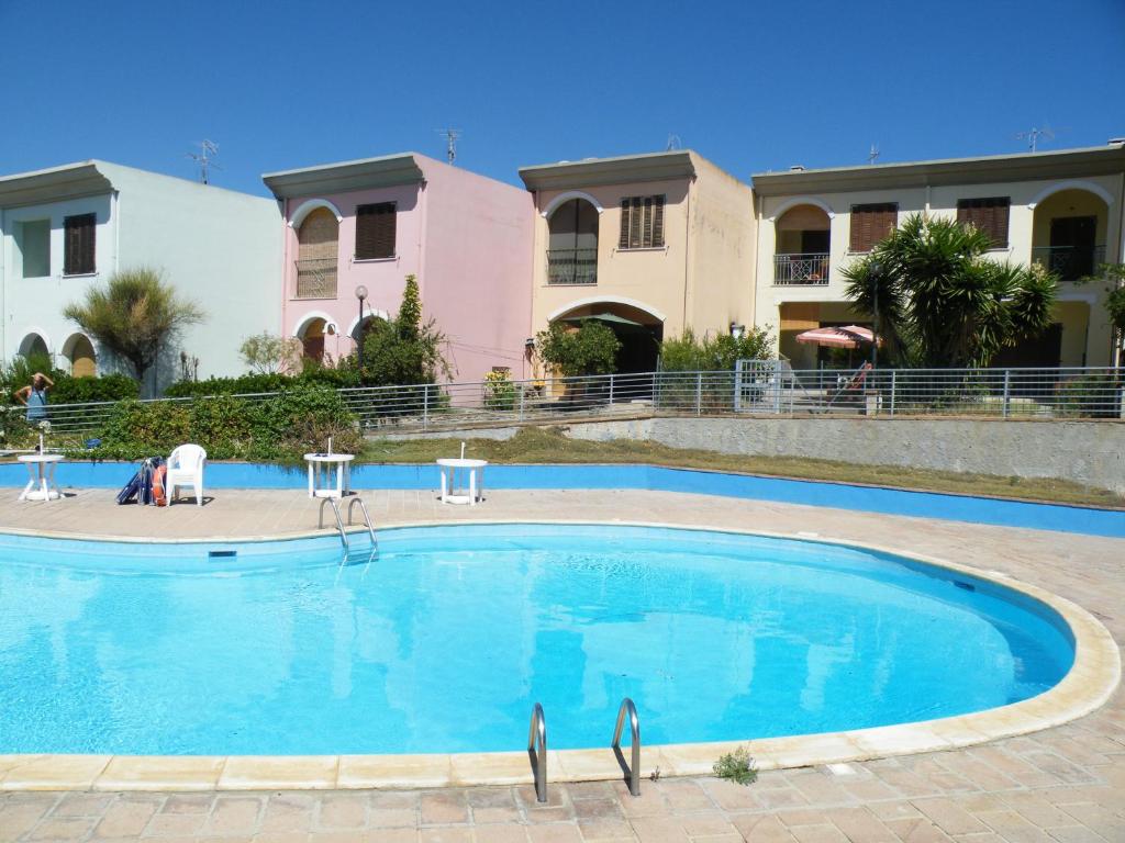 a swimming pool in front of a house at Casa Vacanze I Borghi in Villasimius
