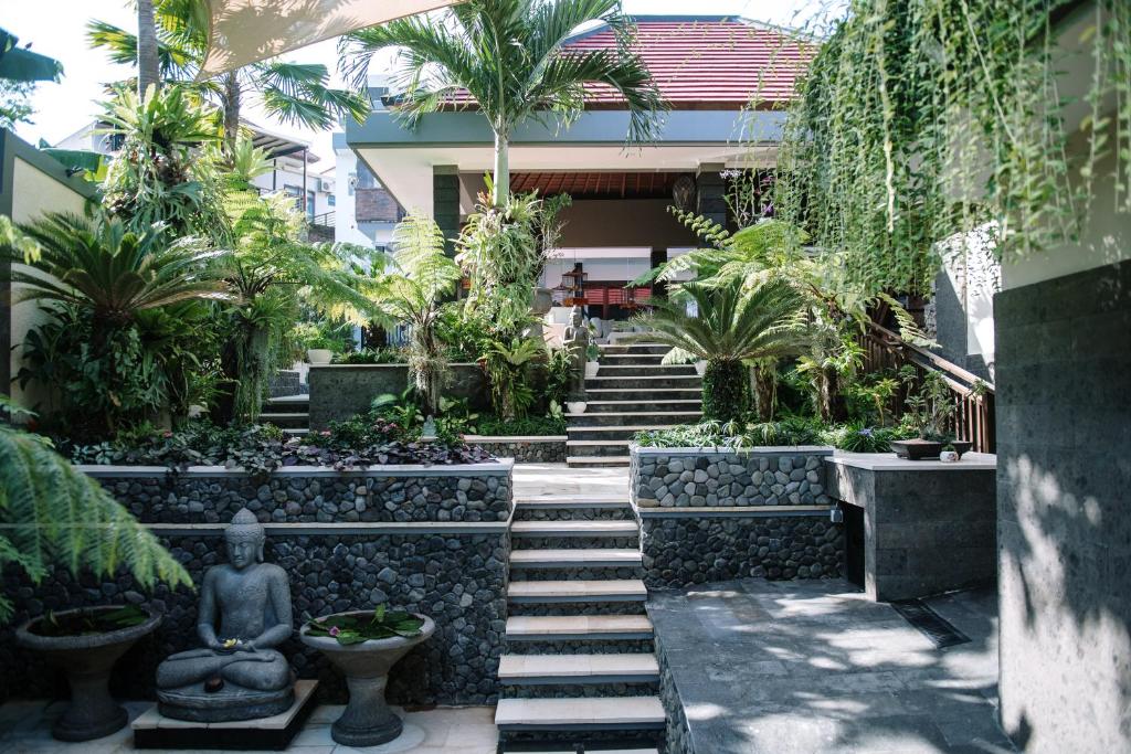 einen Garten mit einer Treppe und einer Statue vor einem Gebäude in der Unterkunft Welcome to Serenity Villa. in Munggu