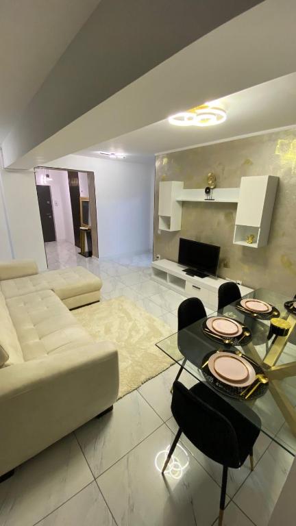 a living room with a couch and a table and chairs at Bucharest luxury apartments Bragadiru in Bragadiru
