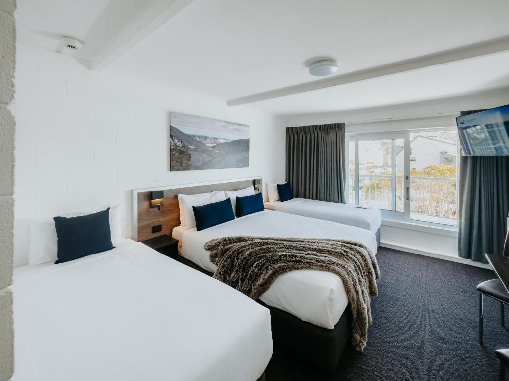 um quarto de hotel com duas camas e uma janela em Falls Creek Hotel em Falls Creek