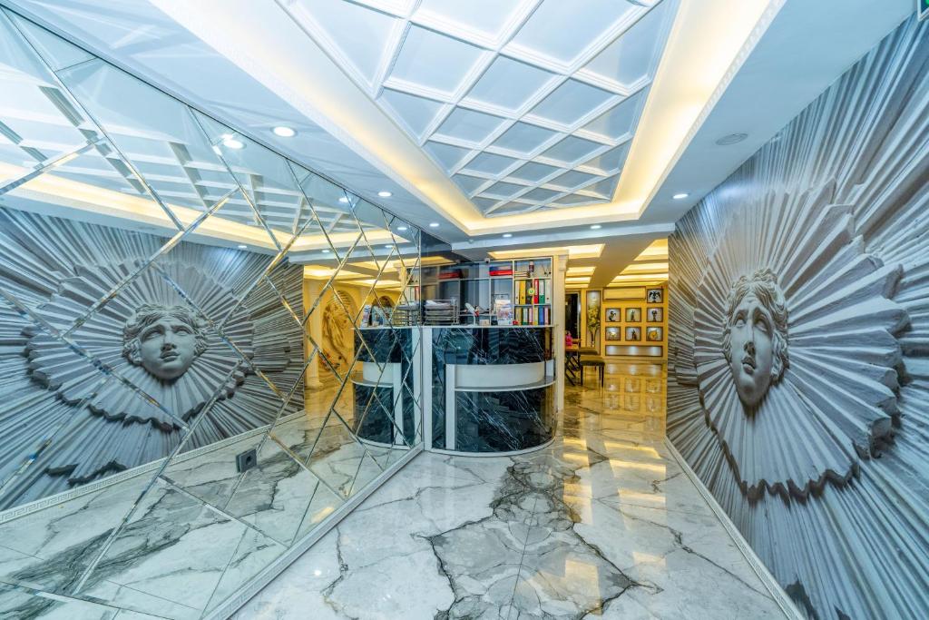 een lobby met marmeren vloeren en een plafond met kunst aan de muren bij Luce Suites Taksim in Istanbul