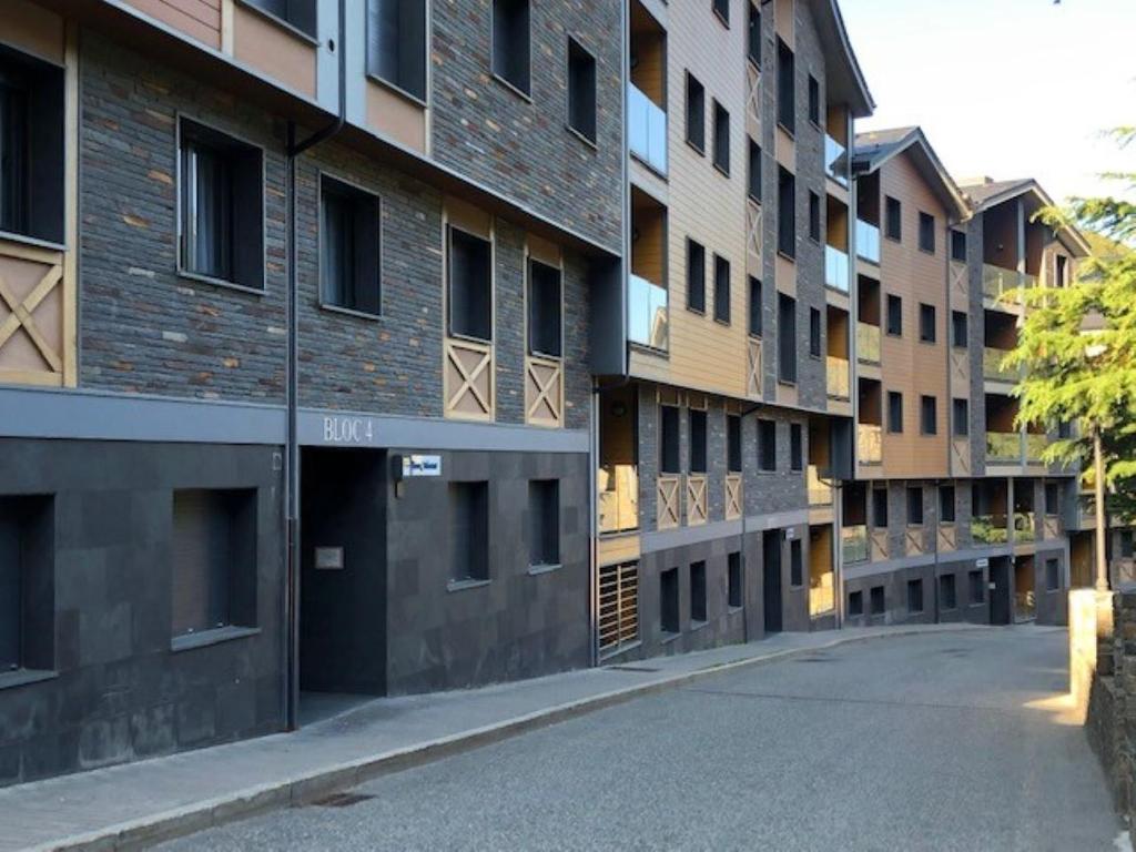 uma rua vazia em frente a um edifício de apartamentos em Apartament La Solana del Tarter 5p - El Tarter - Zona Grandvalira em Sant Pere