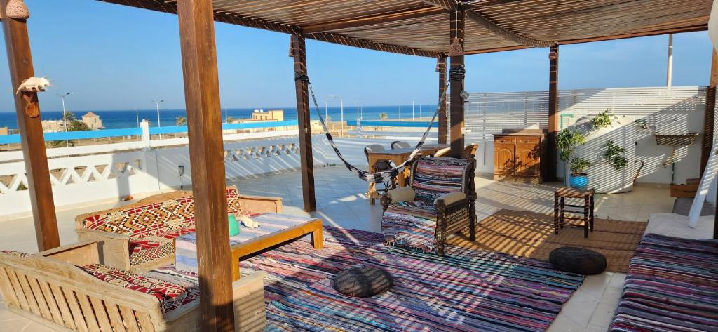 a porch with chairs and a view of the ocean at Rayhana Guest House in Marsa Alam City