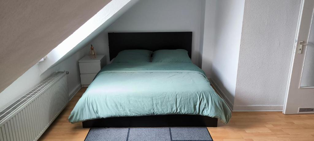 - une chambre avec un lit et une couette verte dans l'établissement PRIVATE ROOM in a Shared Cozy Flat, à Düsseldorf
