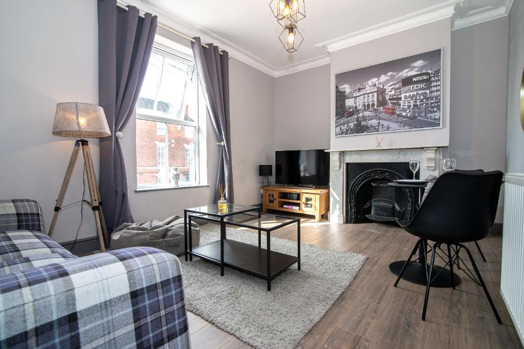 a living room with a couch and a fireplace at Comfortable central Derby apartment - Fast Wi-Fi- Excellent transport links in Derby