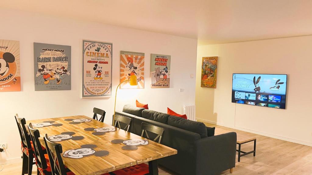 une salle à manger avec une table et une télévision dans l'établissement Appartement Magique à 1,5 km de Disneyland Paris, à Serris