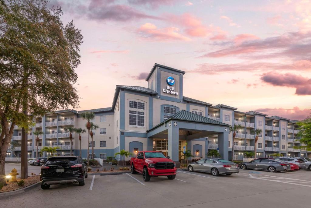 a hotel with a red truck parked in a parking lot at Best Western Naples Plaza Hotel in Naples