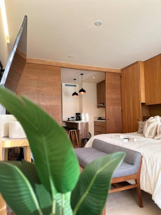 a bedroom with a bed and a chair and a kitchen at Zantamar New cozy beach front apartment in Cruz de Huanacaxtle