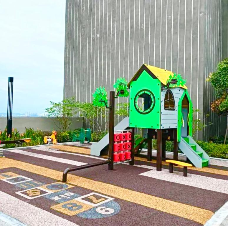 un parque infantil con una estructura de juegos verde en Youth City Studio Deluxe by DKAY in Nilai, en Nilai