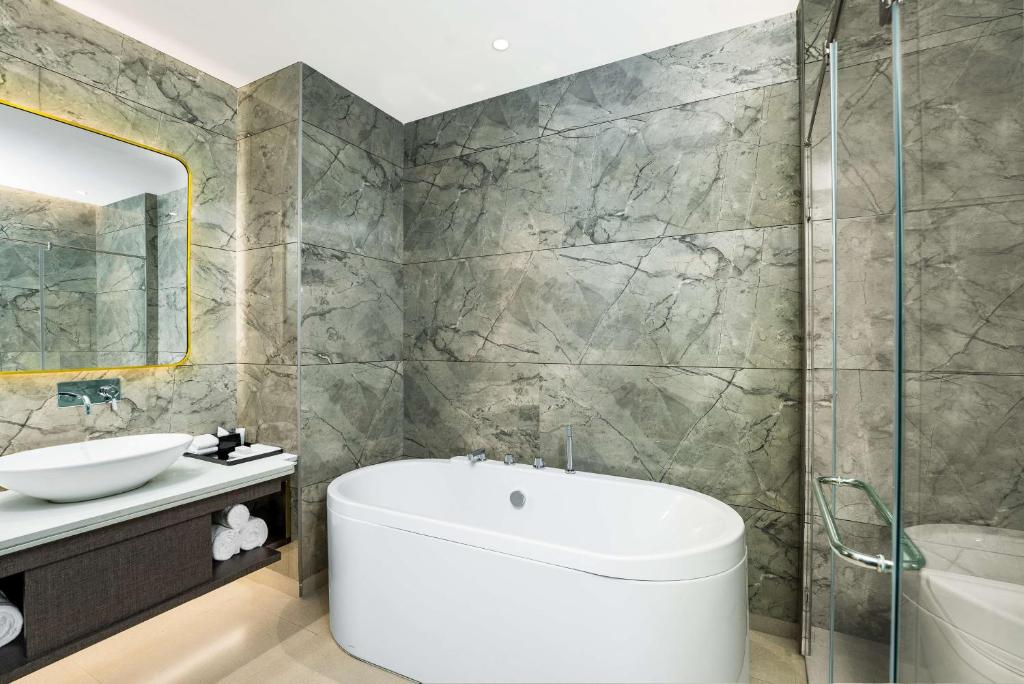 a bathroom with a tub and a sink at DoubleTree by Hilton Hotel Goa - Arpora - Baga in Baga