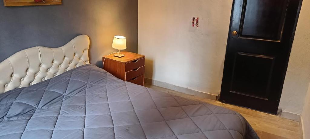 sypialnia z łóżkiem i lampką obok drzwi w obiekcie Luana w mieście Río Cuarto