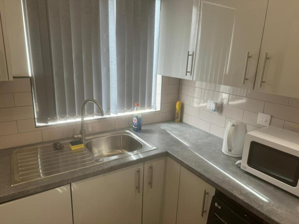 a kitchen with a sink and a microwave at En-Suite Double Bedroom in Manchester in Manchester