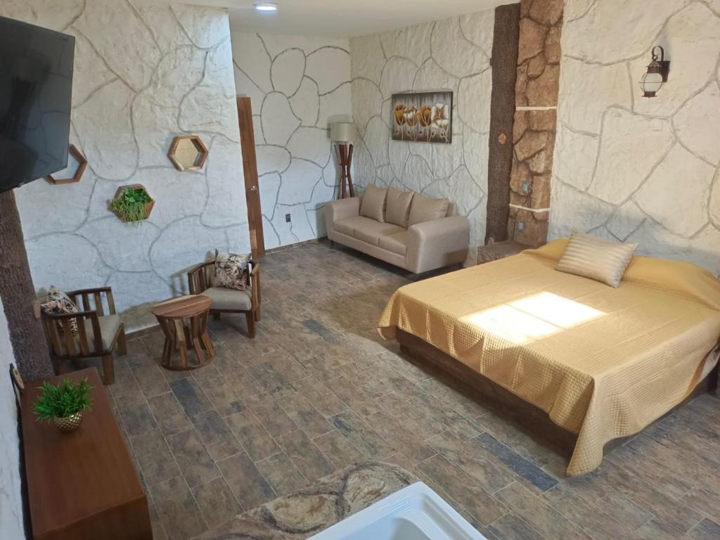 - une chambre avec un grand lit et un canapé dans l'établissement Hotel Spa el Gran Coral By Rotamundos, à Jocotepec