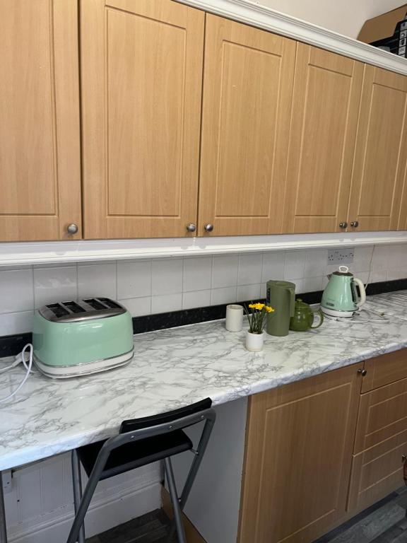a kitchen counter with wooden cabinets and green appliances at Mortiara in Darlington