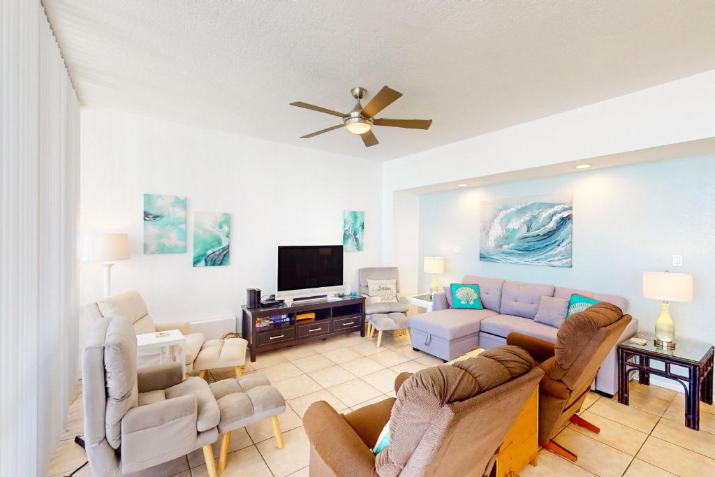 Una sala de estar con un sofá y un televisor. en Sunchase IV #327, en South Padre Island