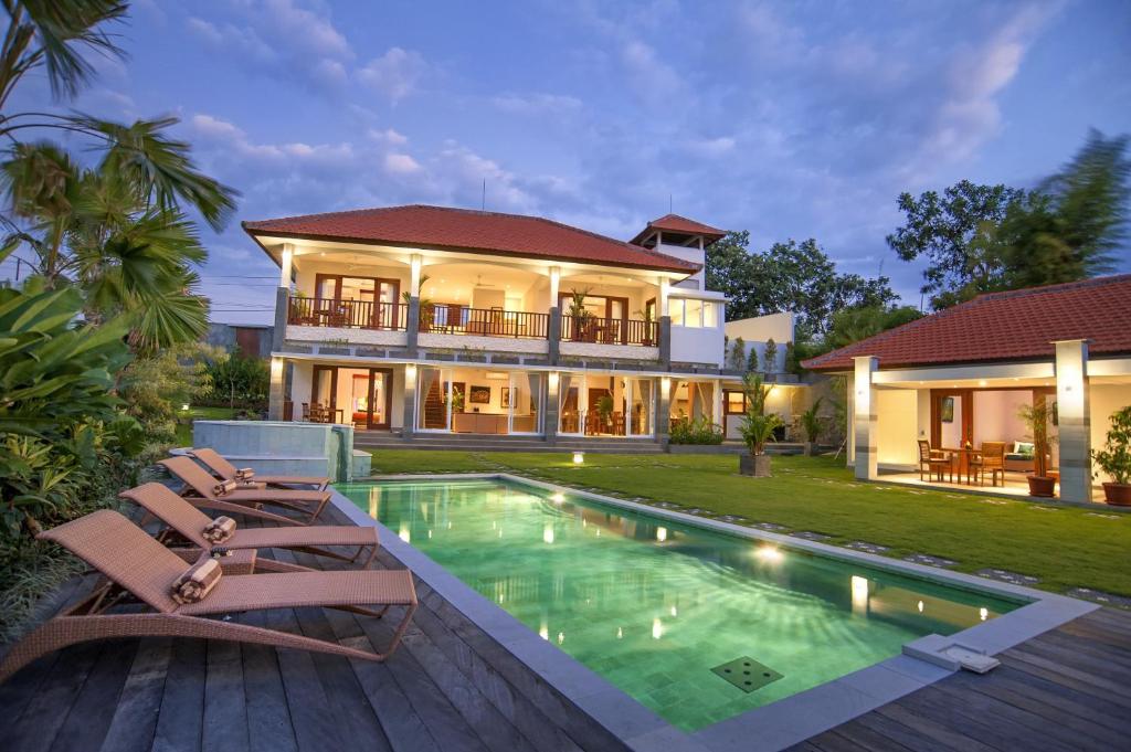 a villa with a swimming pool and a house at Villa Yenian in Canggu