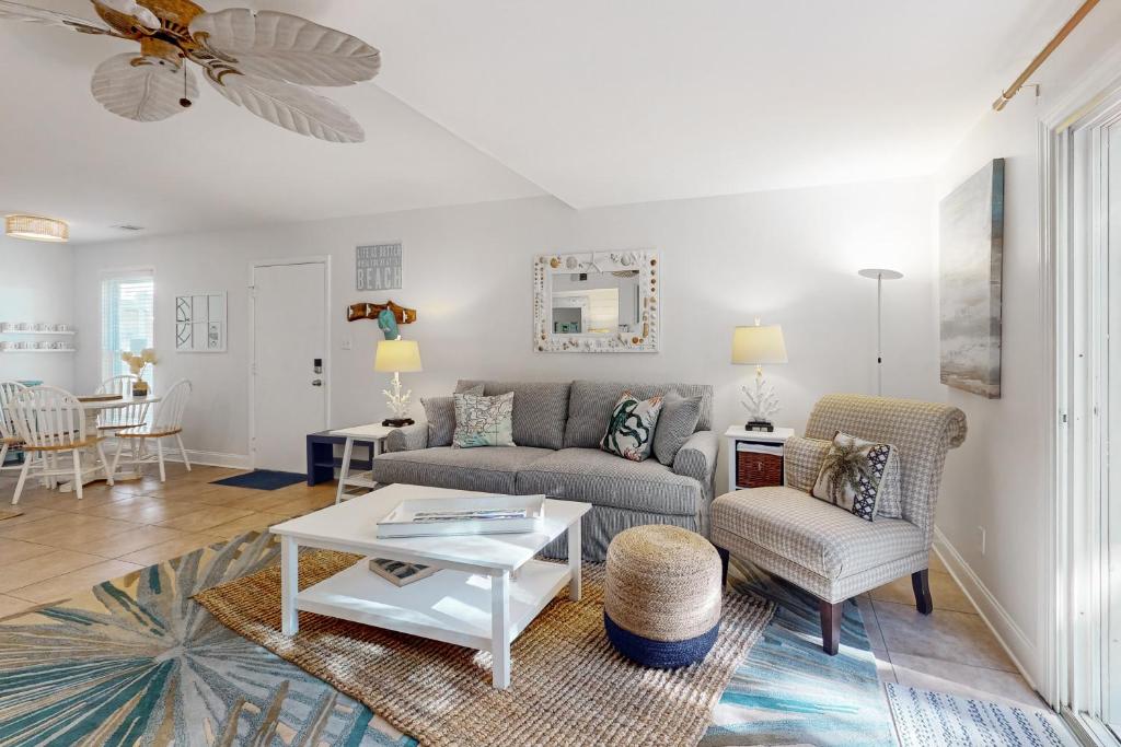 una sala de estar con un sofá y una mesa en Driftwood Villa 270 - Sand Trap, en Edisto