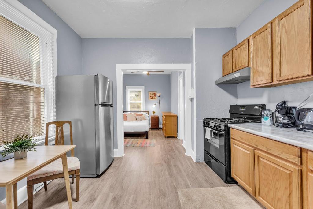 a kitchen with a stainless steel refrigerator and a table at Cozy Med Haven: Little Italy in Cleveland