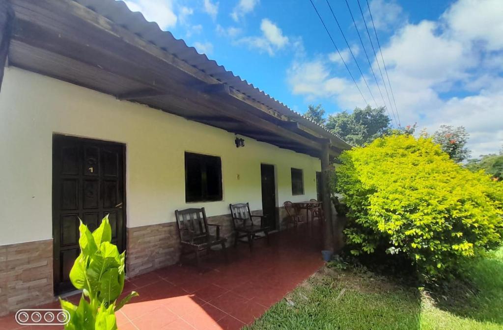une maison avec une terrasse et des chaises dans la cour dans l'établissement Hospedaje Ibera, à Colonia Carlos Pellegrini
