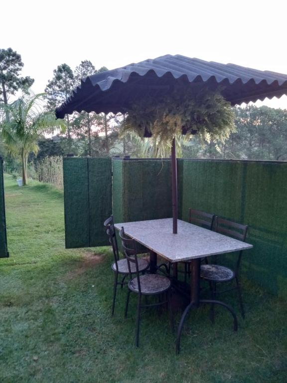 a table and chairs under an umbrella in a yard at casa com bela vista em itatiba in Bragança Paulista