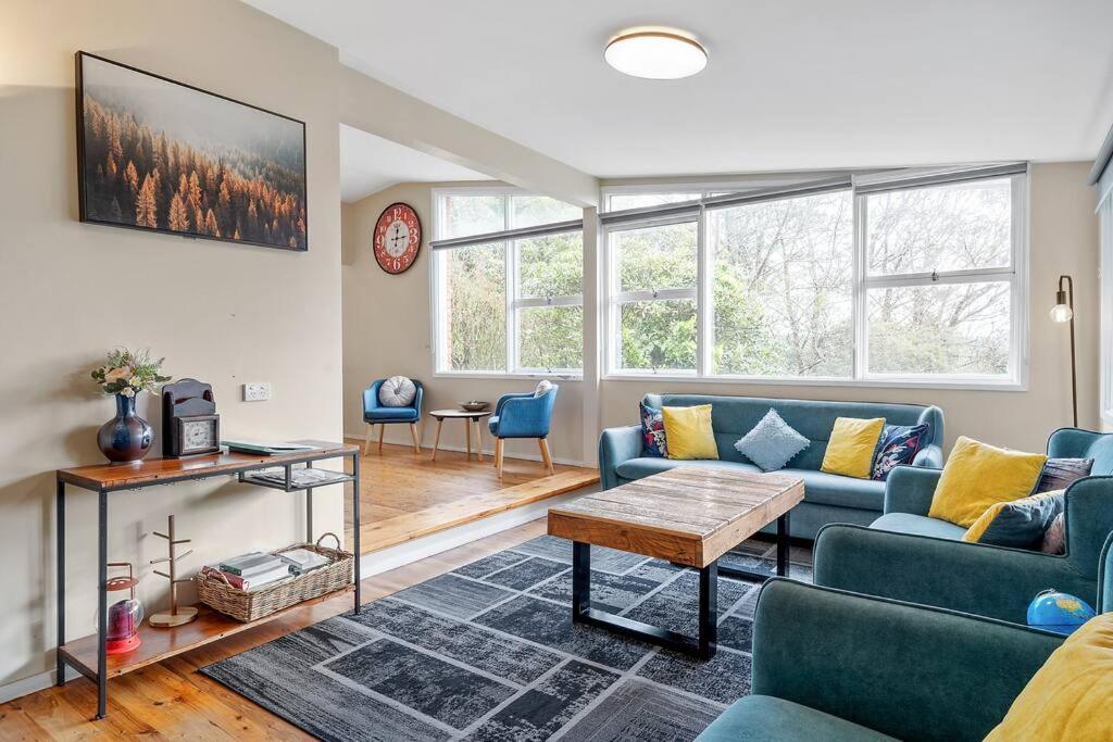 una sala de estar con sofás azules y una mesa. en Green Leaf Retreat-Central to Mountain Attractions-Family Friendly-Pets allowed-Free Parking en Wentworth Falls