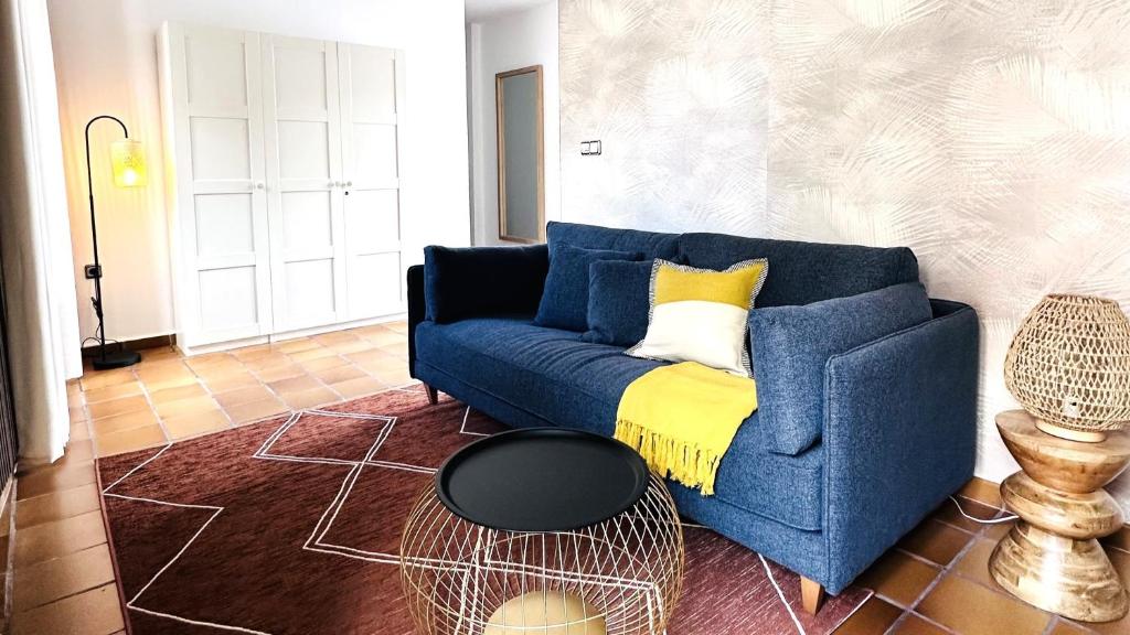 sala de estar con sofá azul y manta amarilla en Cozy Up Spain en Valencia