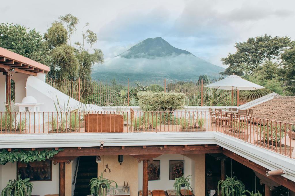 Casa Del Calvario, 3BR Villa in Antigua Guatemala في أنتيغوا غواتيمالا: منزل مع شرفة مع جبل في الخلفية