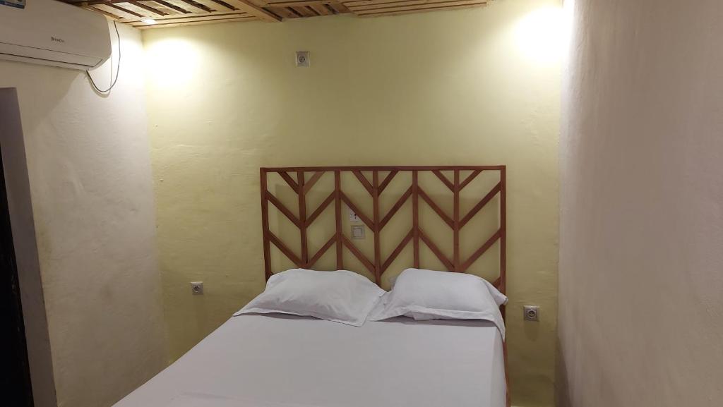 uma cama com duas almofadas num quarto em ETOUDI em Douala