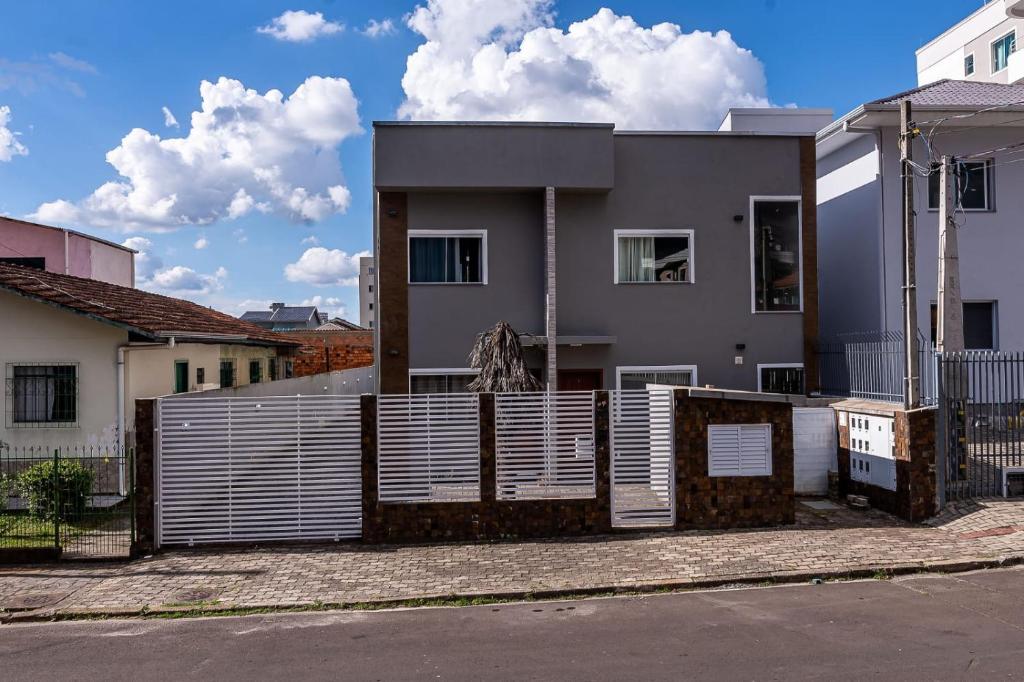 uma casa com uma cerca em frente em Apartamento próximo centro em Lages