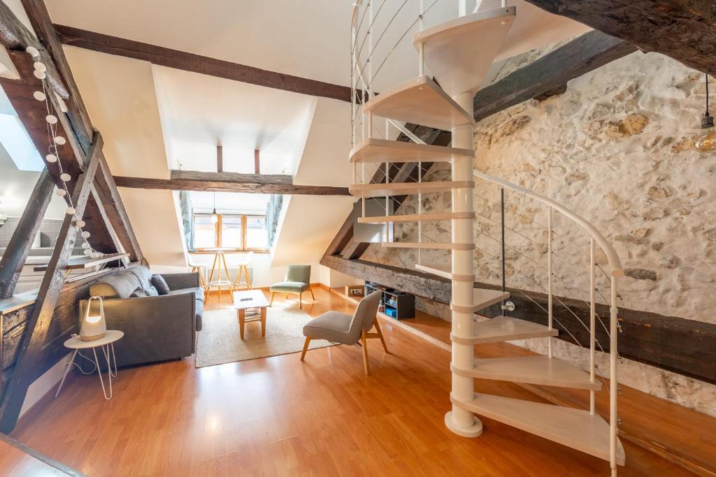 - un escalier dans une chambre dotée d'un mur en pierre dans l'établissement LE PAQUIER T3 - à deux pas du lac, à Annecy