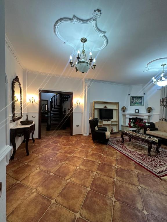 a large living room with a chandelier and a fireplace at Rus Apartment in Berat