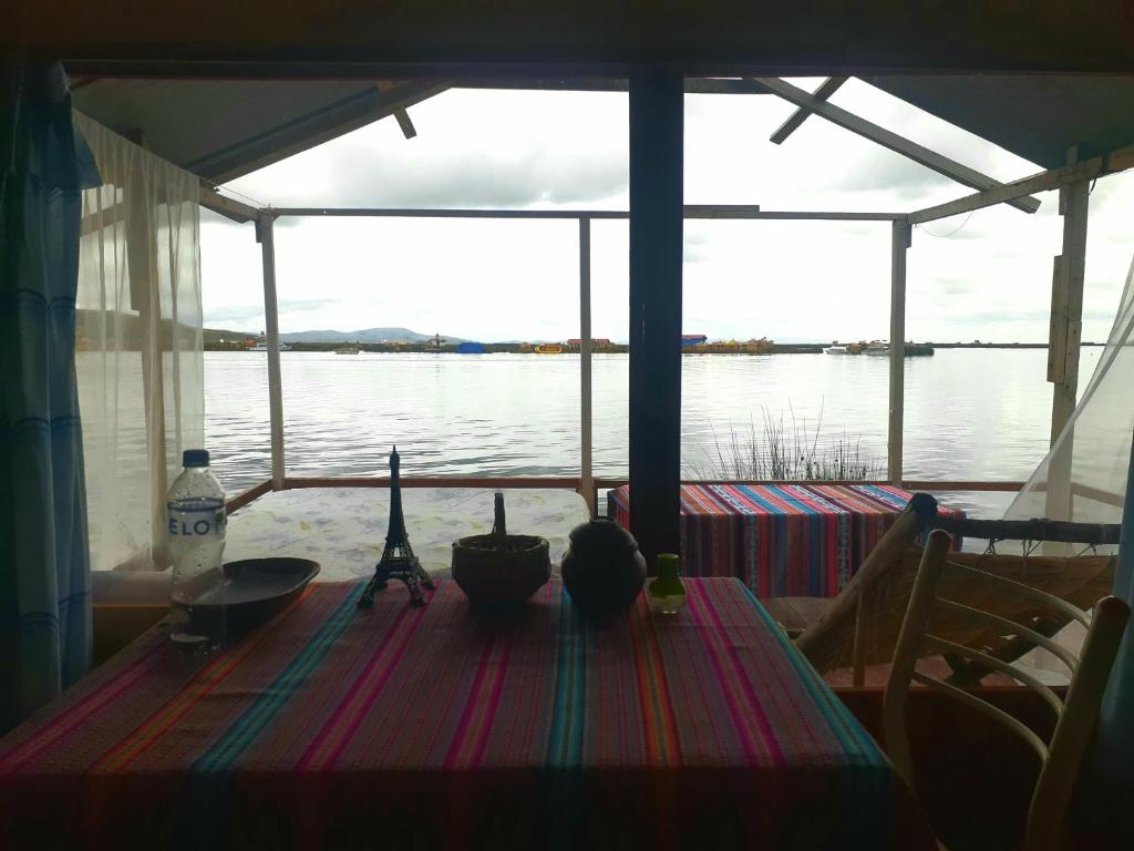 a table on a boat with a view of the water at Uros Suyawi Titicaca Lodge in Puno