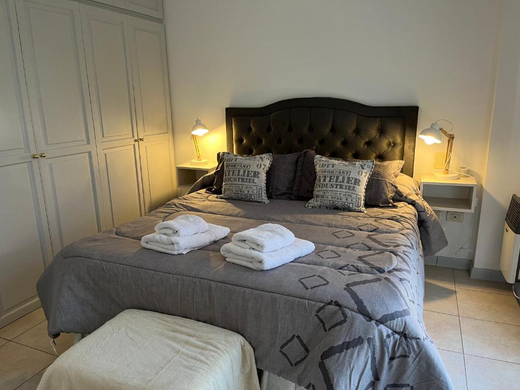 a bedroom with a large bed with towels on it at En el Corazón de la Quinta. in Villa Marini