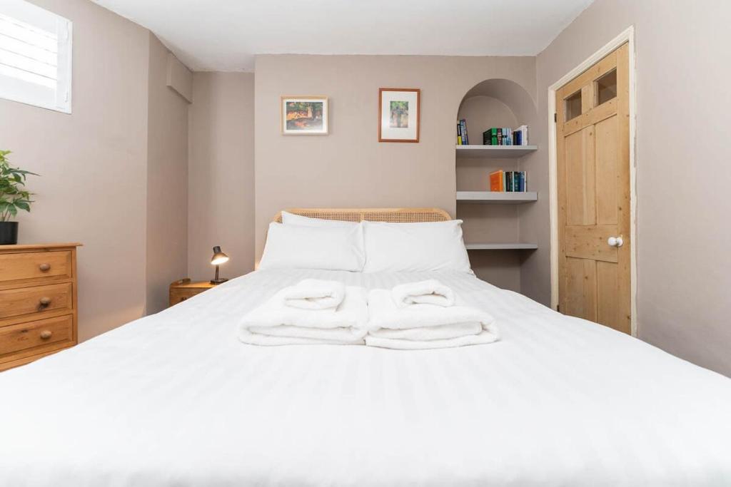 - une chambre avec un lit blanc et 2 serviettes dans l'établissement Garden apartment by the sea, à Brighton et Hove