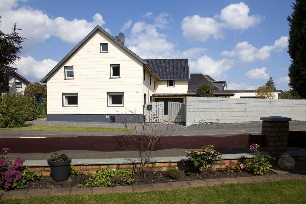 ein weißes Haus mit einem Zaun davor in der Unterkunft Ferienhaus im Grünen Eifel in Schleiden