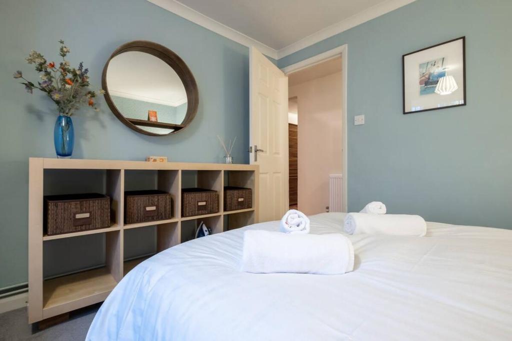 a bedroom with a white bed with a mirror at Quiet & calm apartment with garden in Brighton & Hove