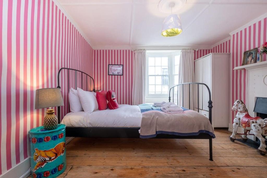 - une chambre avec un lit aux murs rayés roses dans l'établissement Quirky Town House With Garden Near The Seafront, à Brighton et Hove