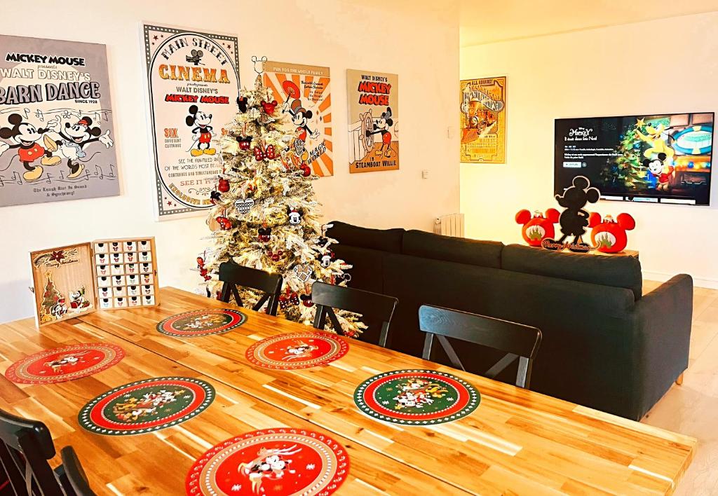a table with a christmas tree in a room at Logement Magique à 1,5 km de Disneyland Paris in Serris