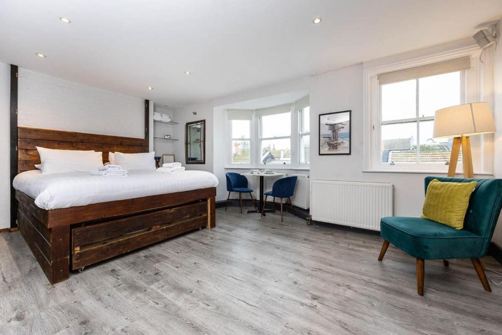 1 dormitorio con 1 cama, mesa y sillas en Cool & Chic Top Floor Studio Flat, en Brighton & Hove